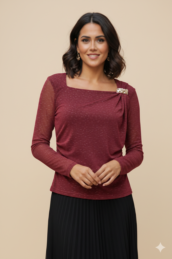 Blusa elegante con mangas transparentes en tela brillante y delicado broche dorado lateral